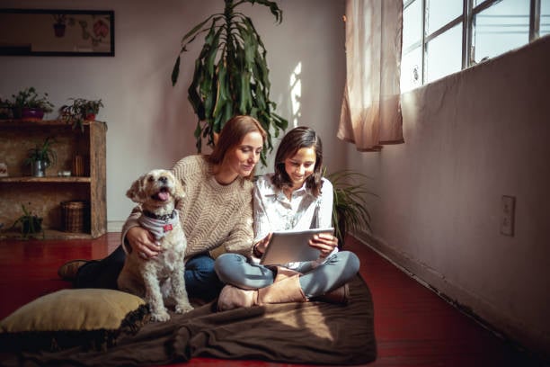 two pet parents buying a pet membership on a tablet with a dog