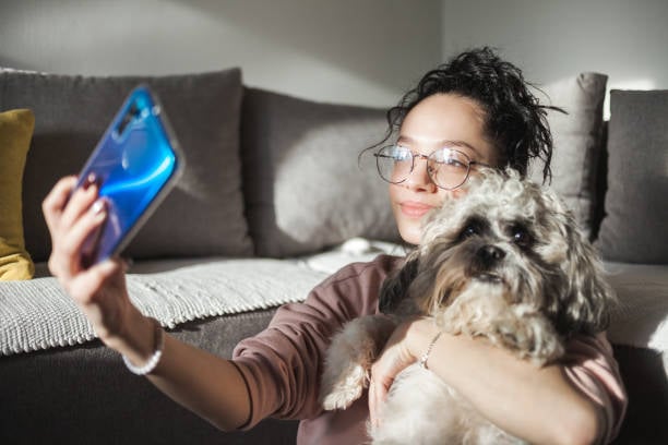 Gen Z pet parent taking selfie with pet dog