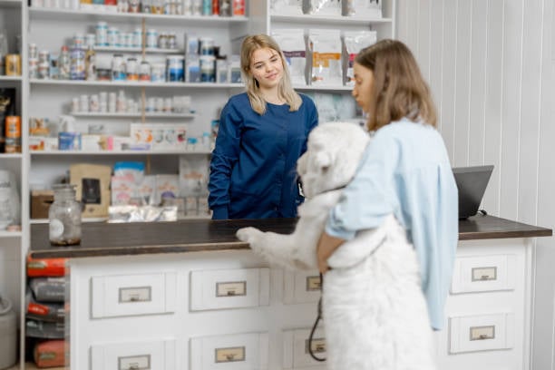 front desk staff member, pet parent and dog with tip jar