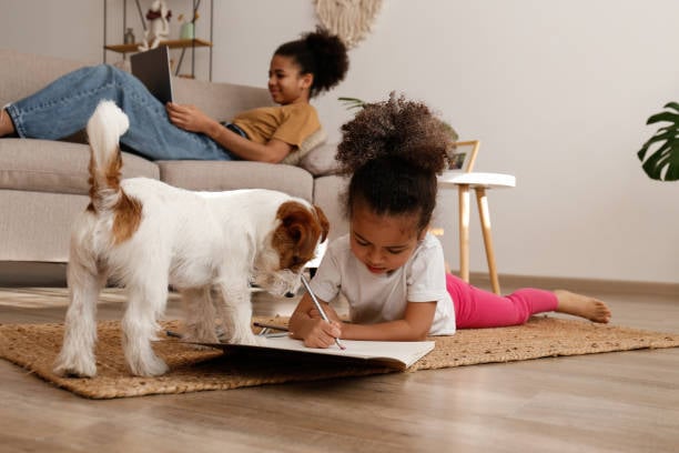 kids doing homework while dog looks on