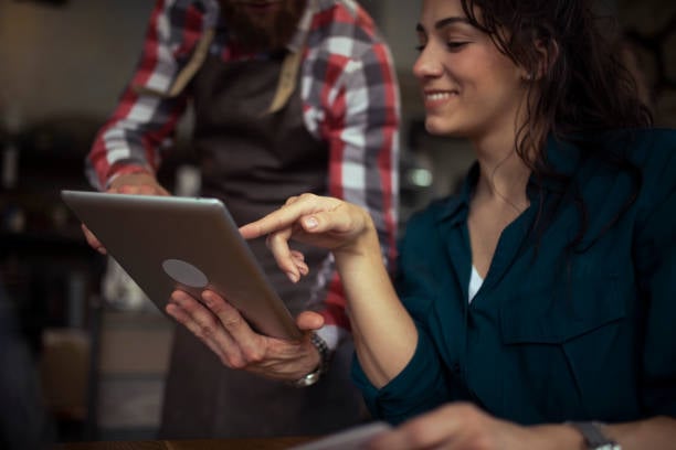 professional services with iPad and business owner tapping button