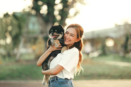 A woman holds a dog outside