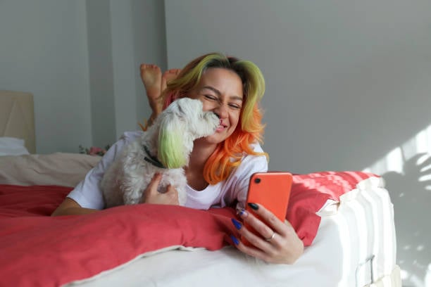 dog groomer with matching hair color as dog on phone