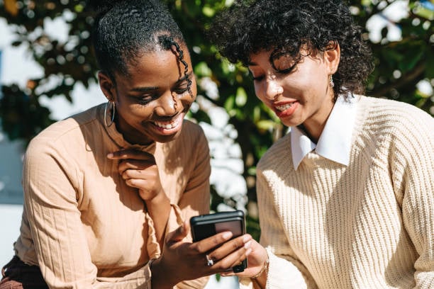 people looking at a phone and smiling