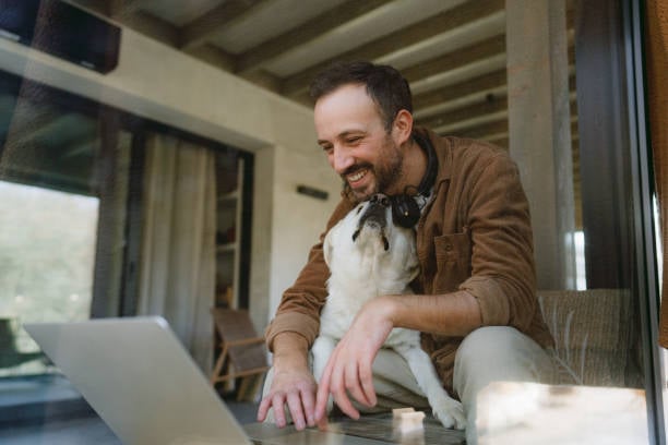 trainer with dog on laptop smiling