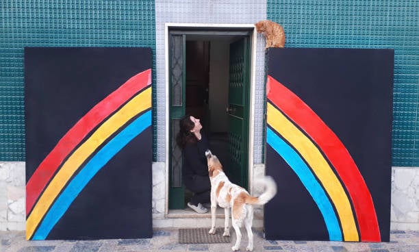 woman with cat and dog outside of pet facility