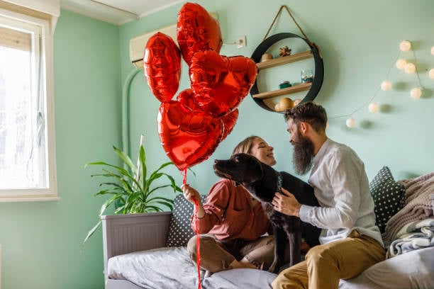 pet parents and dog with heart balloons