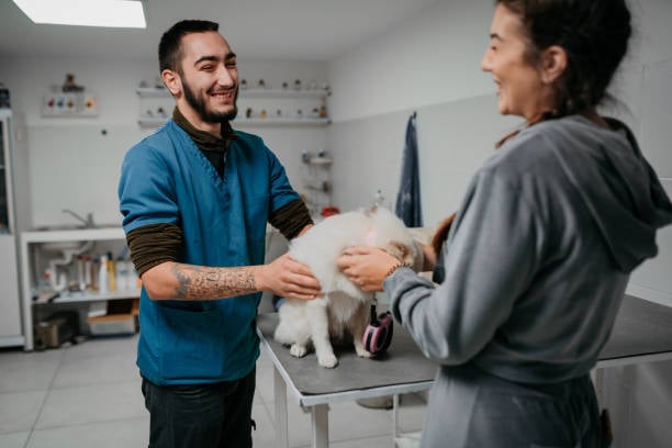 dog groomer and pet parent with little fluffy dog