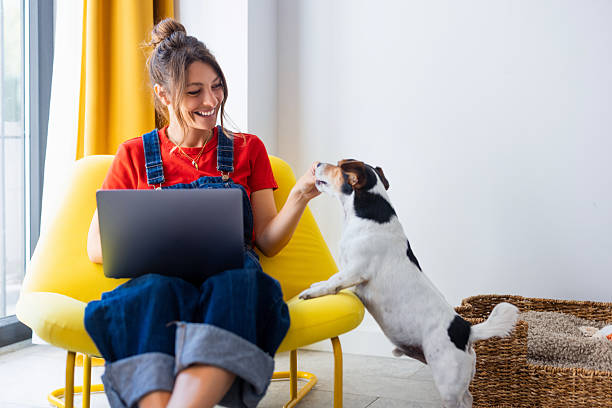 pet care professional smiling on laptop with dog